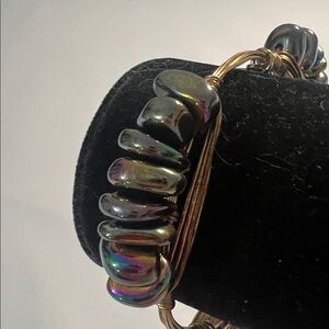 Bourbon and Boweties bangle features iridescent beads signature logo charm.